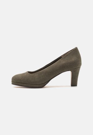 Chaussure à talons hauts en daim vert olive avec un bout arrondi, une texture lisse et une hauteur de talon modérée, présentant un design épuré et minimaliste.