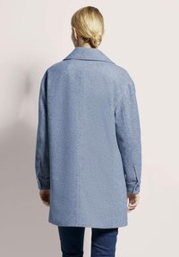 Lichtblauwe jas in visgraatpatroon met een notch-kraag en lange mouwen, voorzien van knopen bij de mouwen en een rechte snit. Achteraanzicht getoond.