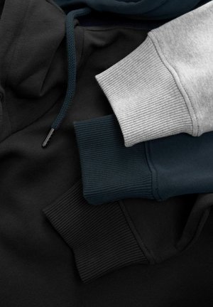 Kolm kapuutsiga särk: must, tume teaal ja hele hall. Omab ribimaalitud varrukaotsasid, paelosi ning sujuvat ja pehmet tekstuuri.