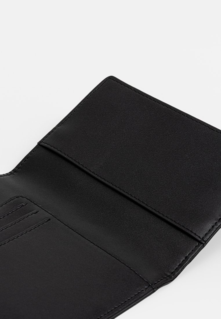 Schwarzes Leder-Bifold-Portemonnaie, geöffnet und zeigt Kartenfächer sowie ein größeres Fach auf hellem Hintergrund.