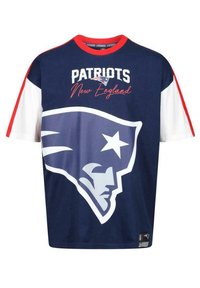 Tummansininen t-paita, jossa on punaisia ja valkoisia yksityiskohtia. Paidassa on iso valkoinen logo patriotin päästä ja teksti "PATRIOTS New England."