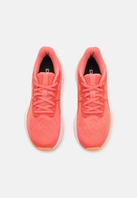 Koralle Lauf-schuhe mit einem strukturierten Mesh-Obermaterial, flacher Schnürung und gepolstertem Kragen. Merkmale sind gelbe Akzente und eine weiße Zwischensohle.