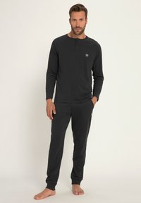 Ensemble de détente pour hommes en noir comprenant un haut henley à manches longues avec boutons et un pantalon assorti, fabriqué à partir d'un tissu doux offrant un confort optimal.
