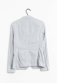 Randig blå blazern med långa ärmar, skräddarsydd passform och knappr detaljer vid ärmsluten. Tillverkad av lättviktsmaterial och har en ren design på ryggen.