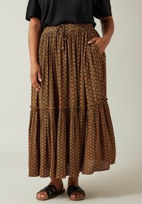 Maxi rok met bruin bloemenpatroon, elastische tailleband en gelaagd ontwerp. Gemaakt van lichte stof, met zijzakken.