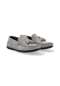 Grijze suède moccasinschoenen hebben een gestikt ontwerp, een kwastje als accent en een flexibele zwarte rubberen zool. Ideaal voor casual gebruik.