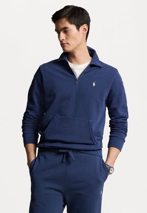 Marineblauwe rits-sweater, van een katoenmix, met een kangoeroezak, geribbelde manchetten en een klein logo op de borst. Gestyled met bijpassende broek.