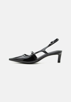 Scarpa slingback in vernice nera con punta appuntita, tacco basso e due cinturini regolabili con fibbia, vista di profilo laterale.