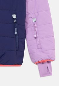 Padded jacket sleeve in navy and light purple, featuring two zippered pockets and elastic cuffs. Contrasting orange lining at the hem.