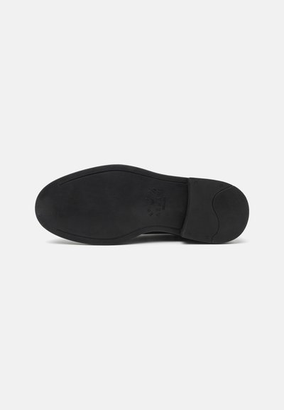 Suola di scarpa in pelle nera con superficie texturizzata, bordi arrotondati e tacco leggermente elevato. Presenta una finitura liscia e opaca senza modelli.
