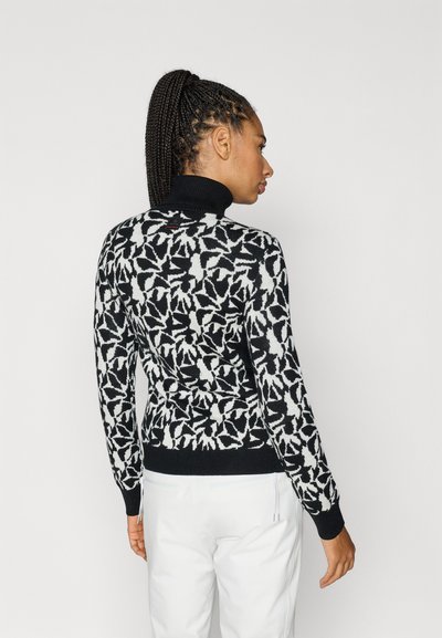 Crno-bijeli pulover s uzorkom, pleten s visokim ovratnikom, s motivom lista, rebrastim manšetama i uskim krojem.