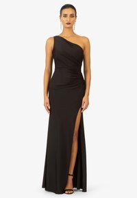 Schwarzes One-Shoulder-Kleid mit Raffung, hohem Schlitz an der Seite und bodenlanger Säume. Weicher, glatter Stoff mit subtiler Dämpfung und minimalistischer Gestaltung.