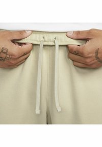 Nike Sportswear CLUB JGGR - Tracksuit bottoms - rattan rattan white