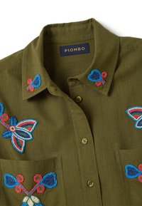 Olijfgroene button-up shirt met kleurrijke geborduurde bloemen met kralen op de kraag, borst en zakken, gelabeld met "PIOMBO" aan de binnenkant van de kraag.