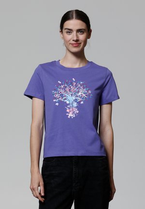 T-shirt en coton violet avec un graphique d'arbre coloré avec des branches et des feuilles, col rond et manches courtes.