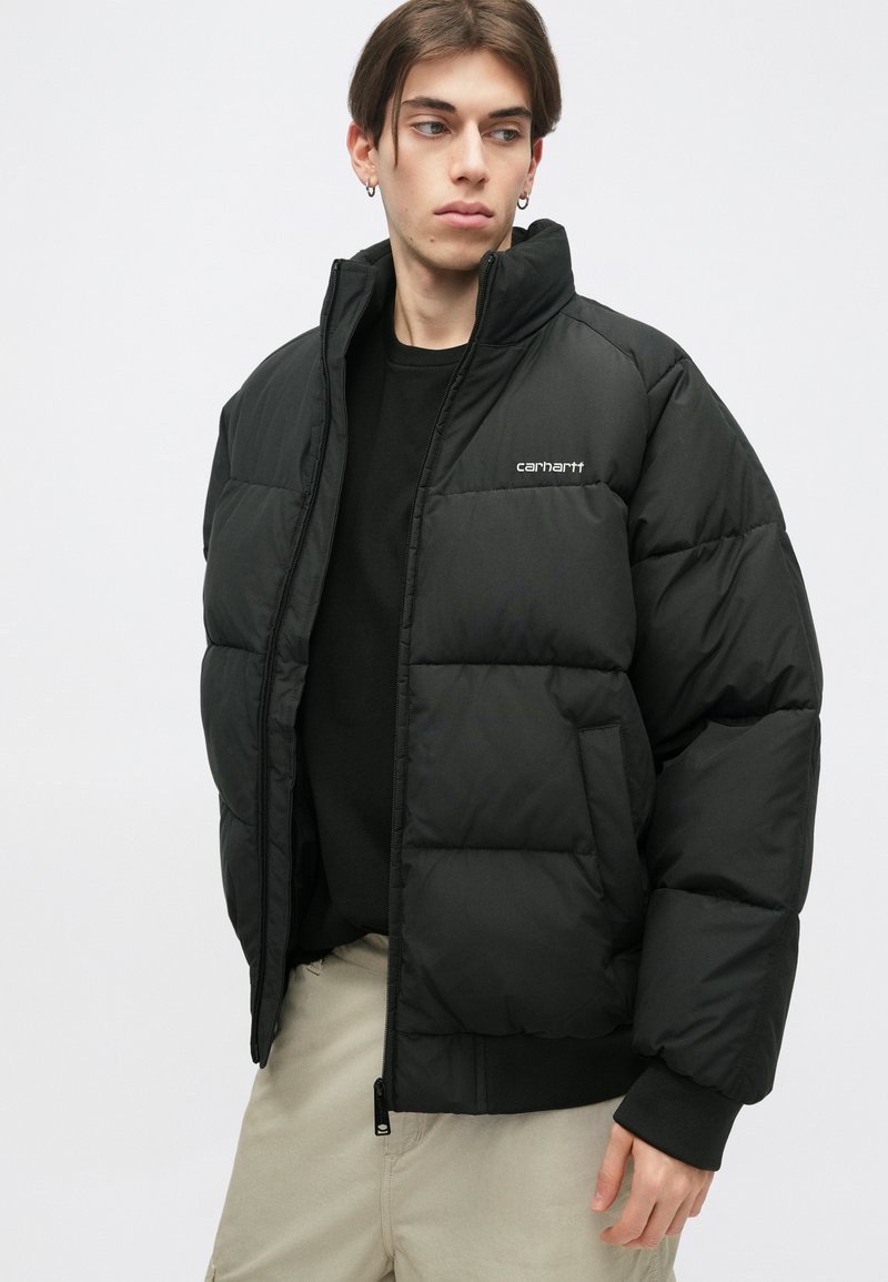 Giacca a vento nera con design trapuntato, colletto alto e due tasche frontali; presenta un logo sul petto e polsini a coste.