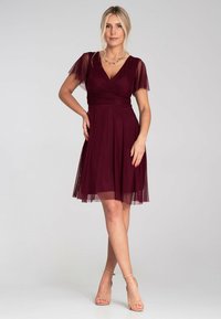 Burgunderfarbenes Kleid mit kurzen, durchsichtigen Flatterärmeln, V-Ausschnitt und tailliertem Oberteil. Der ausgestellte Rock reicht bis zum Knie und hat eine sanfte Textur.