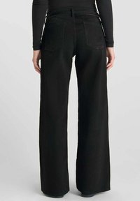 Zwarte denim jeans met wijde pijpen en een hoge taille, van textuurstof met dubbele achterzakken met contrasterende stiksels en een lichte vervaging.