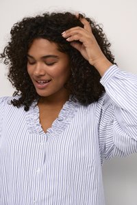 Chemise à rayures bleu clair et blanche avec un col froncé, manches longues et tissu doux. Présente de petits boutons sur le devant.