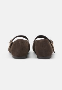 Scarpe flat in suede marrone con cinturino sulla parte posteriore e dettagli in oro. Il design presenta una punta arrotondata e una superficie liscia.