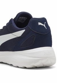 Tenisky Puma so sieťovaným horným dielom v námorníckej farbe, s bielym akcentovaným logom, polstrovaným golierom, textúrovanou pätou a bielou gumovou podrážkou.