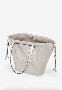 Bolsa de tote de mimbre beige con un parche de acento suave y pálido y detalles de tachuelas plateadas. Presenta correas de cuero delgadas y ajustables, y un interior espacioso.