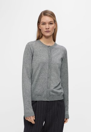 Grå cardigan laget av myk stoff, med rund hals, lange ermer og knappelukking foran. Teksturert ribbestrikkede mansjetter.