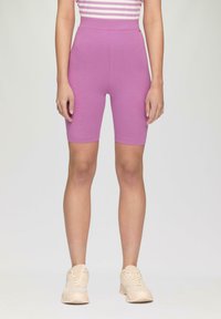 Shorts de vélo ajustés violets à taille haute. Matériel doux et extensible avec une texture lisse. Pas de motifs visibles ni de détails métalliques.