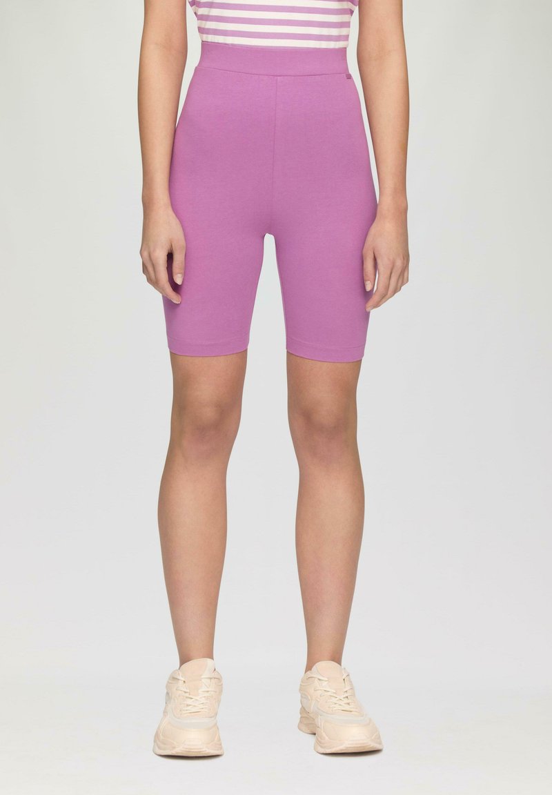 Shorts de vélo ajustés violets à taille haute. Matériel doux et extensible avec une texture lisse. Pas de motifs visibles ni de détails métalliques.