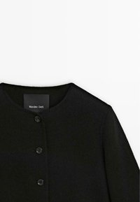 Black wool-blend coat with a round neckline, featuring button closures and a soft, textured finish. Label visible inside the collar.