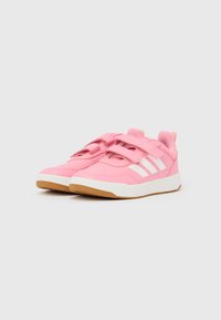 Rožnate športne copate z belimi črtami, z zgornjim delom iz sintetičnega materiala in zapiranjem na ježka. Gumijast podplat za boljši oprijem.