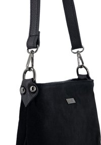 Sort ruskindshåndtaske med en tekstureret læderrem, der har metalbeslag og et markant vedhæftningsdetalje på den ene side.
