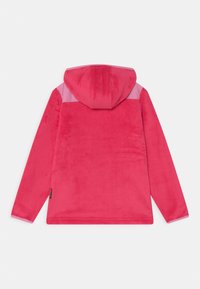 Fleecejacka i stark rosa med huva. Har en mjuk textur och kontrasterande ljusare rosa paneler på axlarna. Inga synliga knäppningar.