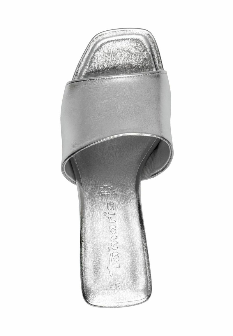 Silberne Rutschsandale mit breitem Riemen, quadratischer Zehenpartie, metallic glänzender Oberfläche und flacher Sohle. Markenlogo auf der Innensohle eingeprägt.