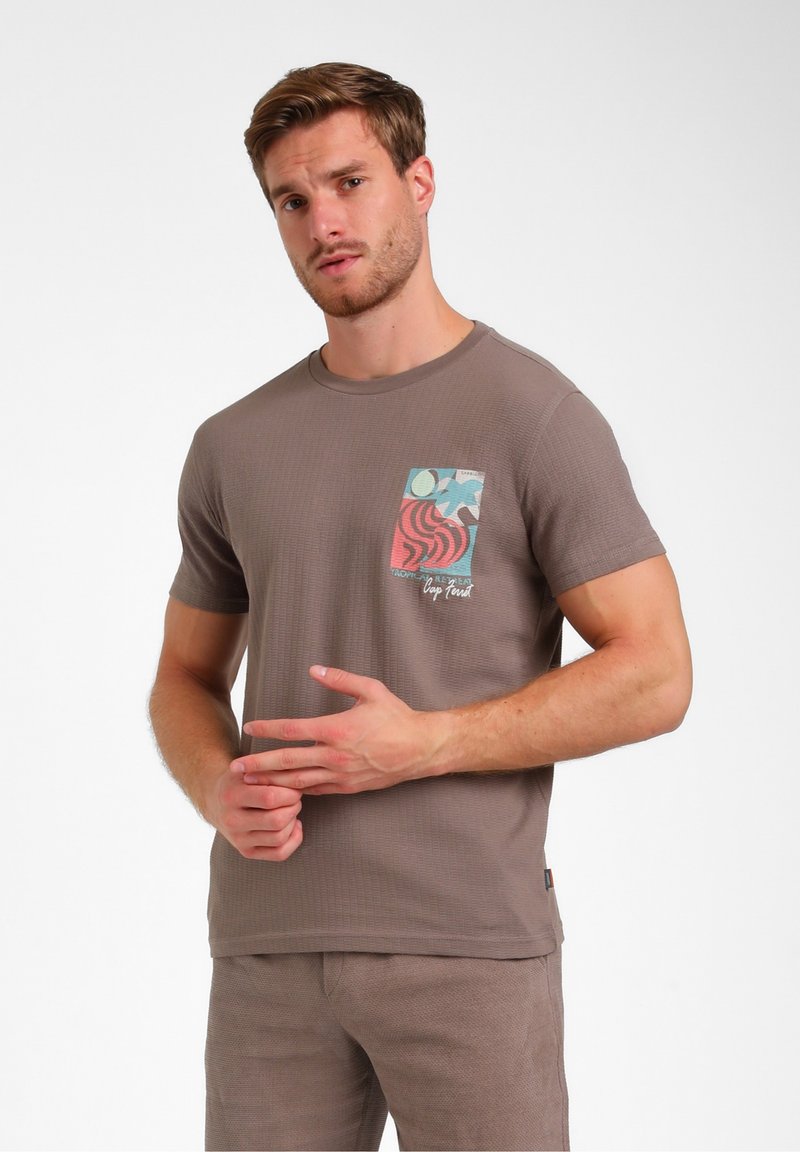 Bruine getextureerde t-shirt met ronde halslijn en korte mouwen. Beschikt over een kleurrijke patroontas op de borst met abstracte ontwerpen en logo.