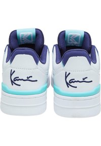 Vita sneakers med marinblå accenter, nät-tunga och ljusblå sula. Har den signatur "Kani" broderad på hälen.