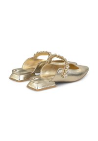 Chaussures à talons ouverts métalliques dorées, avec un bout triangulaire, une lanière ornée de strass et un petit talon carré. Texture lisse.