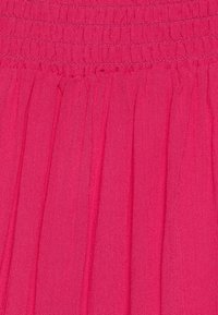 Tessuto fucsia con texture plissettata, caratterizzato da una vita smock. Il materiale sembra leggero e morbido, adatto per un abbigliamento casual.