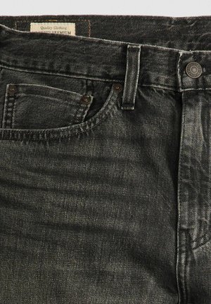 Jean en denim gris foncé avec une texture légèrement décolorée, présentant un design classique à cinq poches, une fermeture à bouton et des détails de couture visibles.