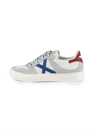 Sneakers i grå ruskind og hvidt lærred, med en blå diagonalt stribe og rød hælaccent, med mønstrede snørebånd og en struktureret sål.