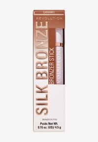 Silk Bronze Bronzer-Stick in Karamellfarbe, untergebracht in einem weißen Behälter mit roségoldenen Akzenten, zeigt kräftige Typografie auf einem braunen Hintergrund.