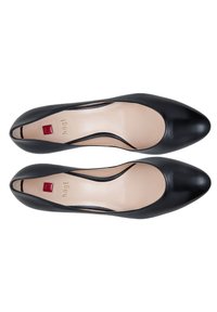 Paire de ballerines pointues pour femmes en cuir noir avec semelles intérieures beige et logo carré rouge sur la zone du talon, vues de dessus.