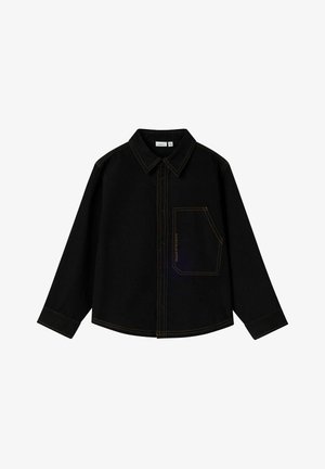 Melnā garenā piedurkņa pogājama krekla ar kontrastējošiem oranžiem šuvumiem un slīpu krūšu kabatu kreisajā pusē.