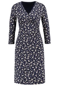 Marinblå omslagsklänning i slät tyg med ett mönster av dandeljonfrön i vitt. Den har långa ärmar och en dekorativ krage.