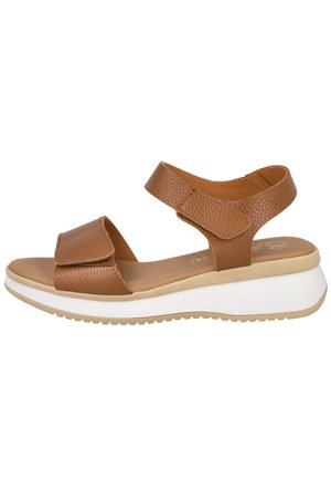 Sandalia de cuero marrón con correas ajustables sobre los dedos y el tobillo, plantilla acolchada y suela plataforma blanca con agarre texturizado.