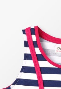 Pruhovaná tílko s námořnickými modrými a bílými vodorovnými pruhy, růžové akcenty na výstřihu a průramech, vyrobené z měkké látky.