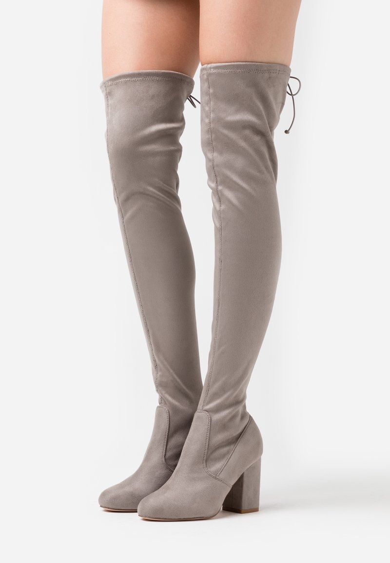 Botas gris de ante hasta el muslo con tacón bloque, que presentan una textura suave y una parte trasera elástica para un diseño ajustado. Suela de goma para mayor agarre.