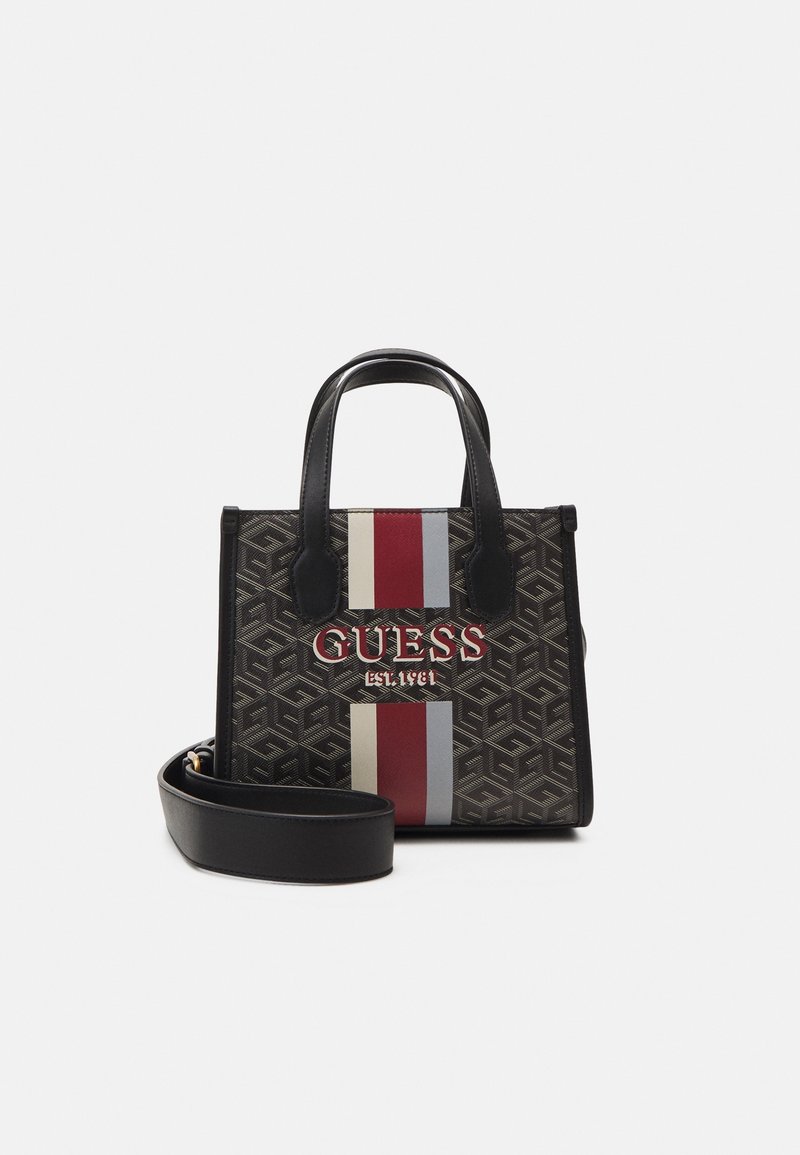 Mustat kuviolliset käsilaukut, joissa on valkoinen ja punainen raita, joissa on näkyvä "GUESS"-logo. Mukana lyhyet kahvat ja irrotettava olkahihna.
