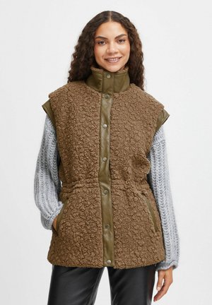 Gilet en fausse fourrure marron avec un col et un panneau avant en olive matelassé. Il comprend des boutons à pression et des poches latérales.