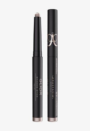 Black retractable eyeshadow stick labeled "Glidr Shadow Stick Pearl" by Anastasia Beverly Hills with silver-tipped cap removed and placed beside it.